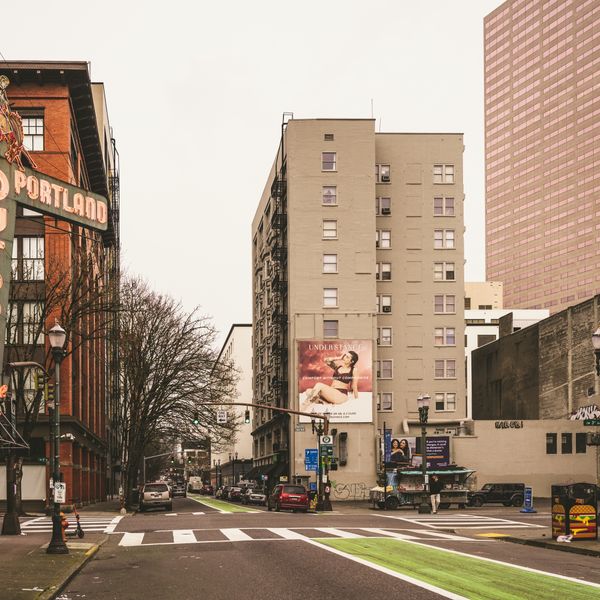 A downtown Portland street corner with a pedestrian crossing and the Old Town sign