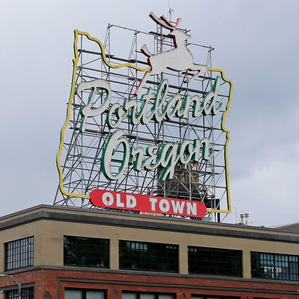 The historic Portland Oregon Old Town neon sign atop a brick building
